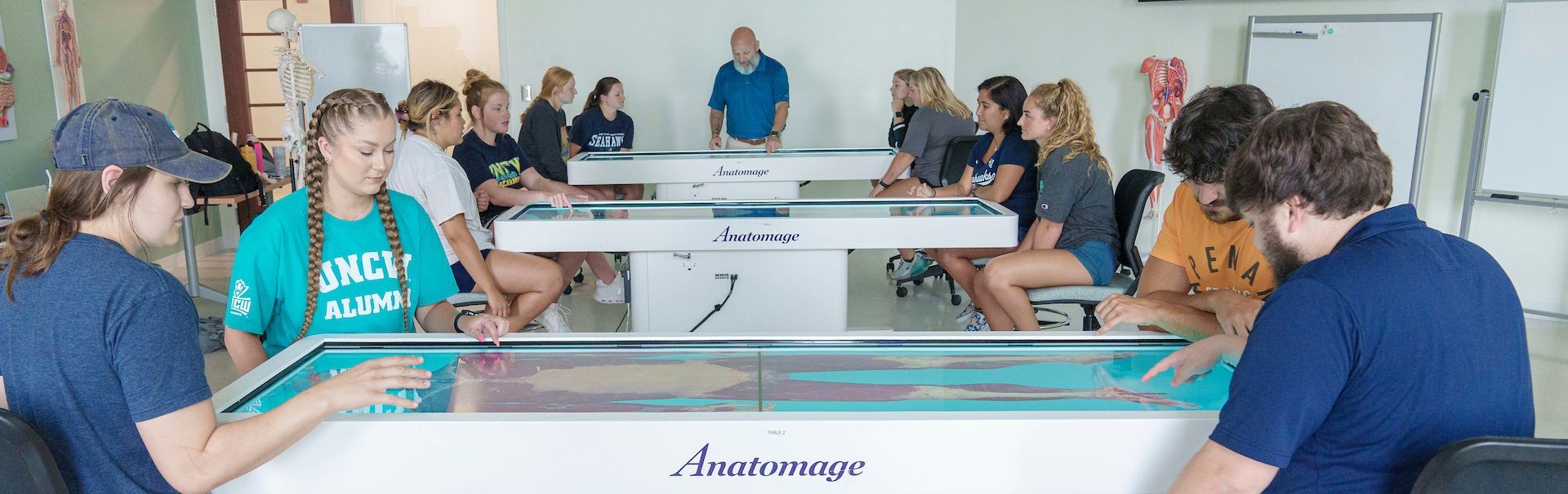 Students sit around an Anatomage Tables as part of their Anatomy courses