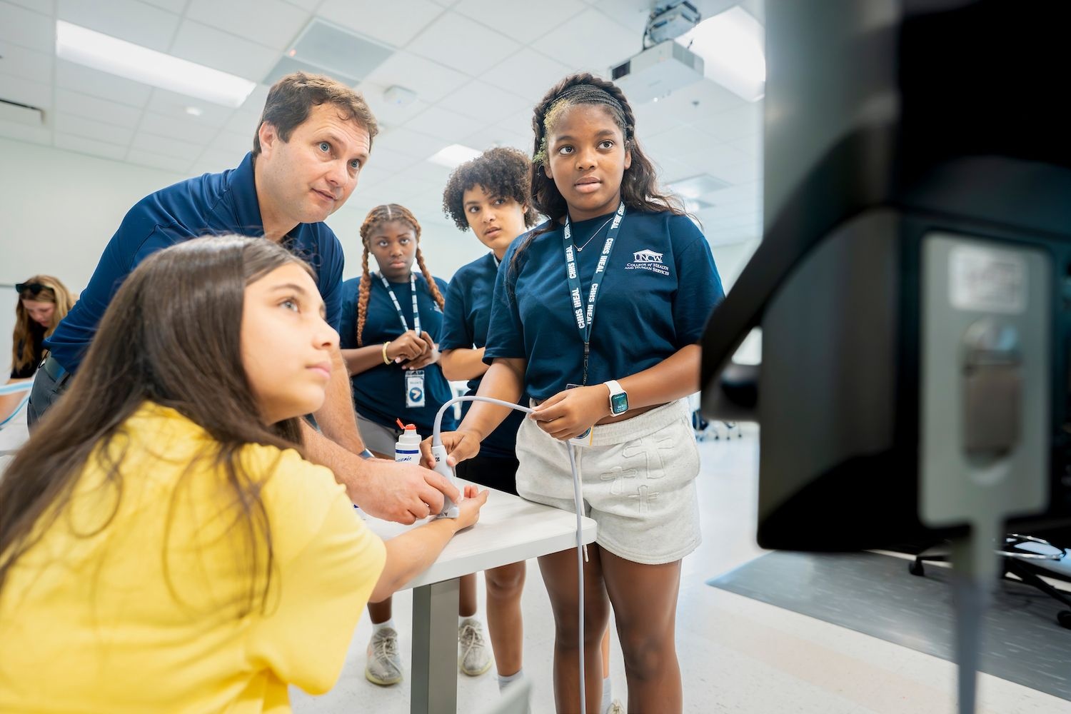 Several iHEAL students experience a wrist ultrasound while touring various healthcare simulation labs on the UNCW campus. 