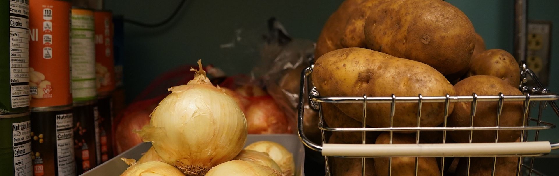 Shelves at Hawk's Harvest are full of food items such as onions and potatoes.